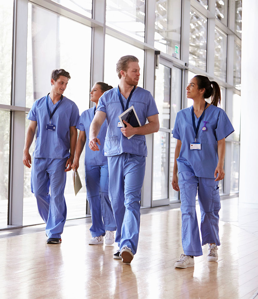 Group of nursing students walking down brightly lit hallway